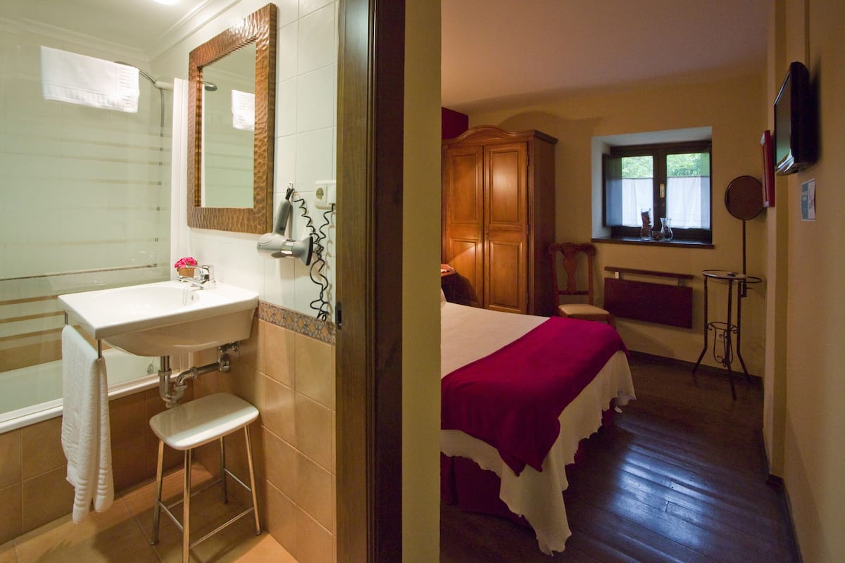 A bathroom with a sink, mirror, and shower.