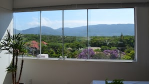 A room with a large window offering a view of mountains and greenery. - Hotel Don Zepe (Florianópolis)