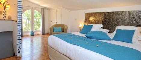 Un dormitorio con una cama grande, una silla y vistas al exterior.