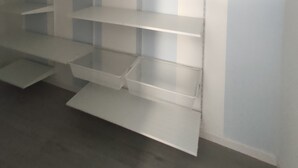 A room with white shelving units against a wall, with no visible windows or doors. - Casa Marina (Cagliari)