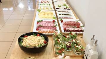 A buffet table with various food items and a salad bar.