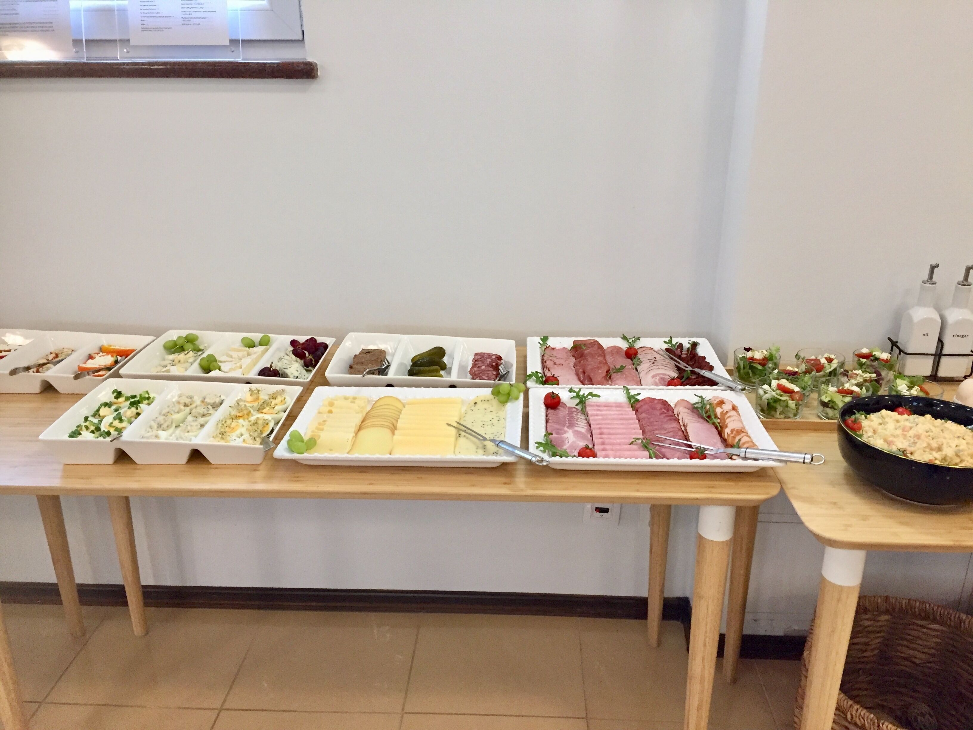 A buffet table with various food items and a salad bar.