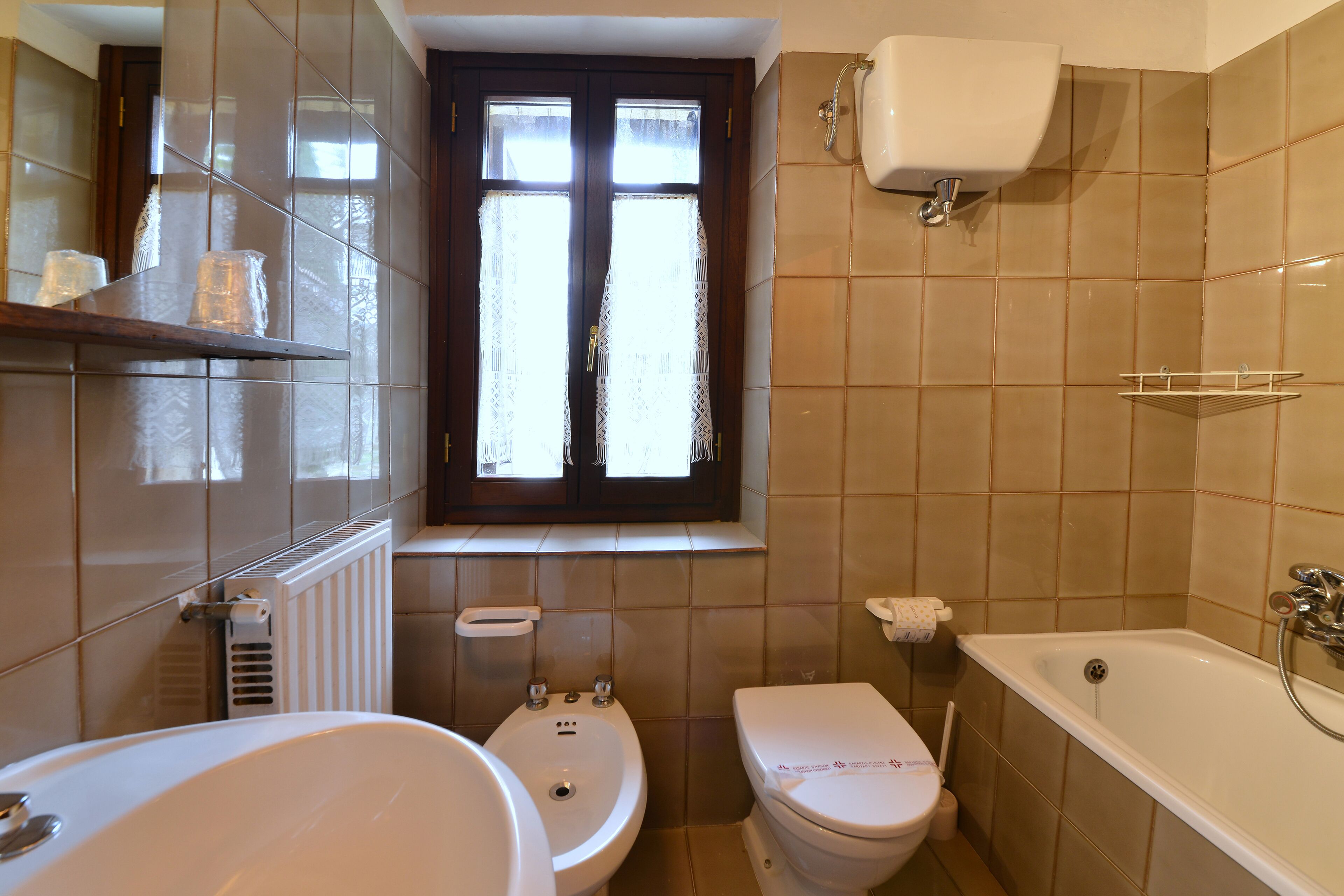 A bathroom with a toilet, sink, and bathtub.
