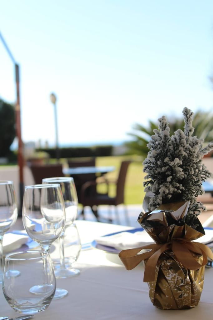 A table set with clear glasses and a decorative plant in a gift box.