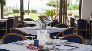 A dining area with tables set for service, chairs, and a view of the outdoors. - Hotel Parco dei Principi (Capaccio-Paestum)