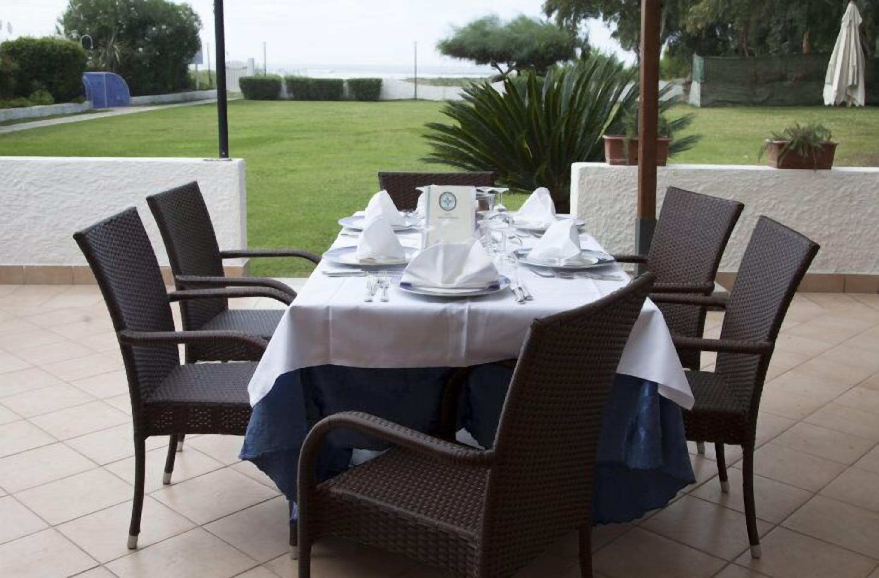 Mesa posta para quatro com vista para o mar.