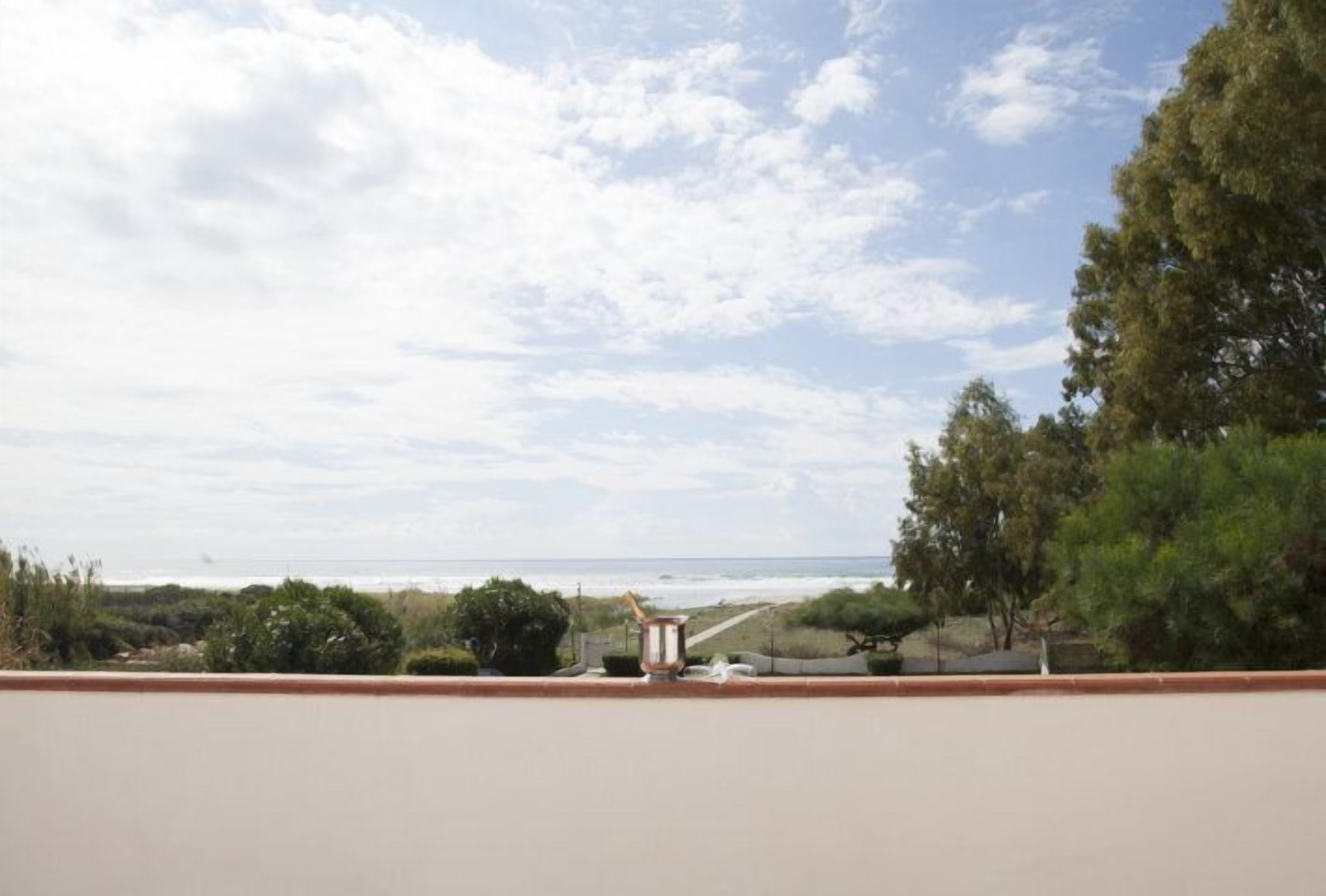 Un balcón con vista al océano y a la playa.