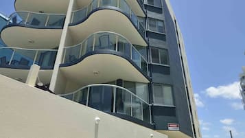 Un edificio moderno con varios balcones y una piscina.
