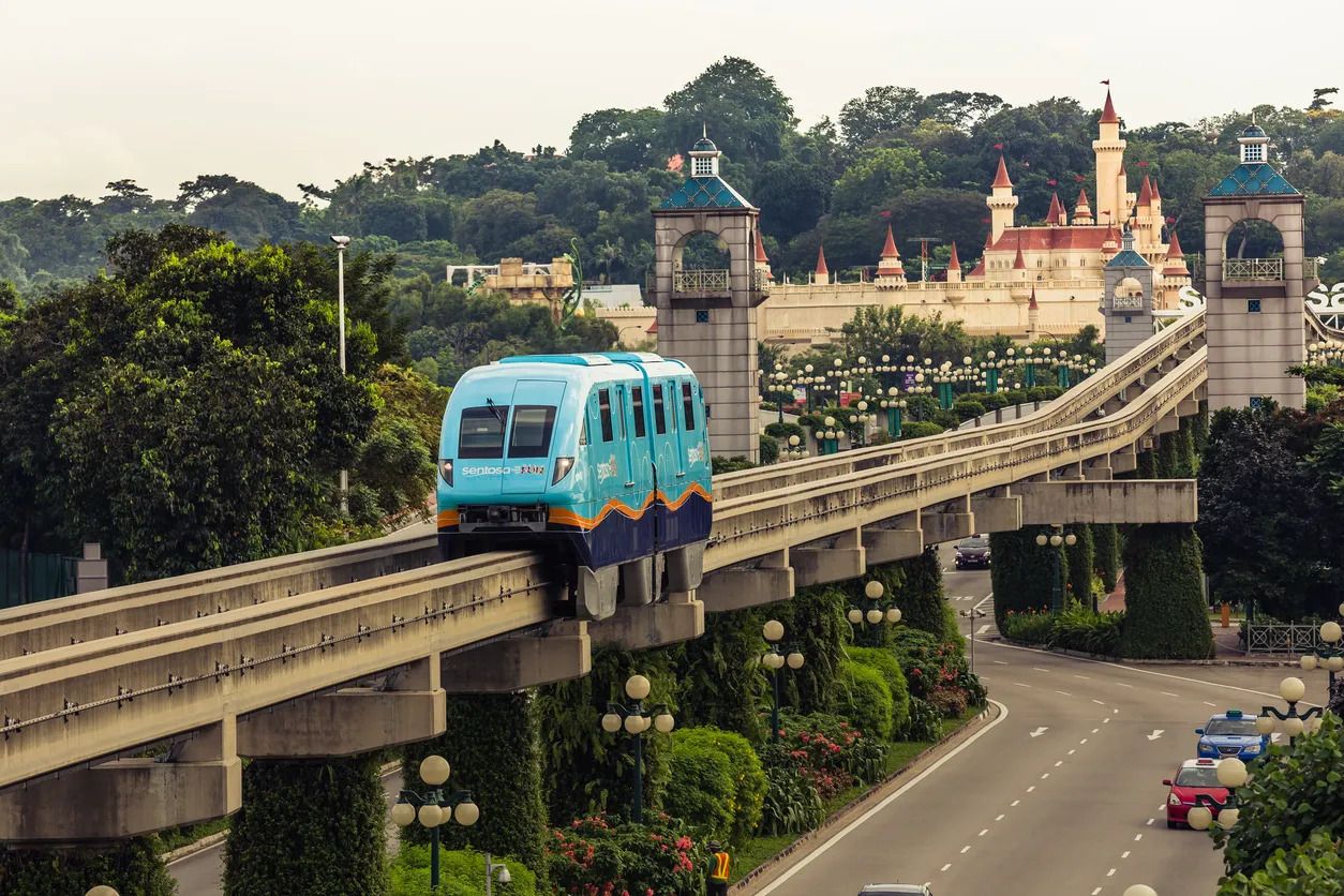 Eine blaue Straßenbahn auf einer Brücke, im Hintergrund ein Schloss.