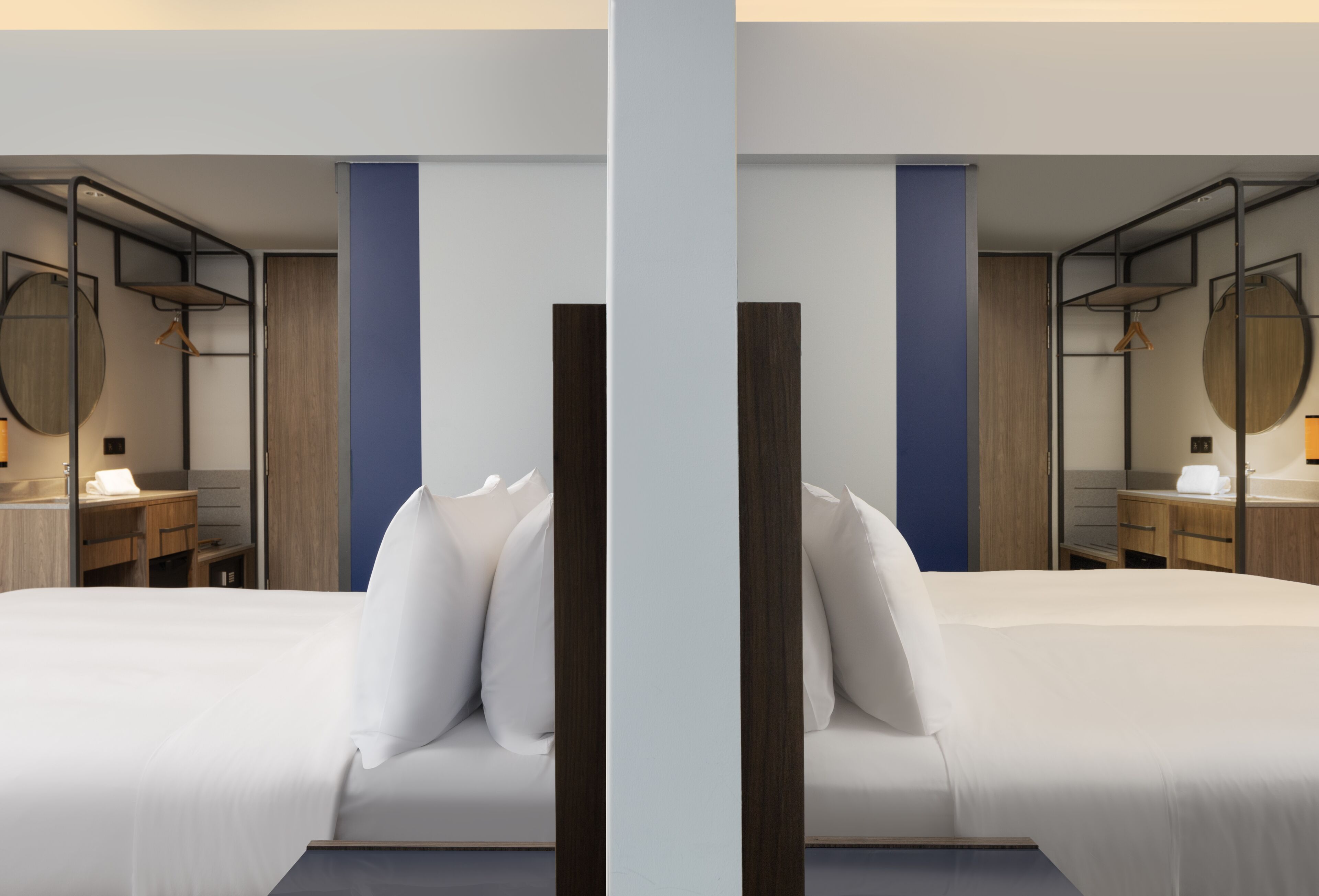 Una habitación de hotel moderna con cama, escritorio y armario.