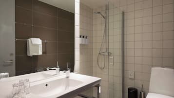 Un baño moderno con un lavamanos grande, una cabina de ducha de vidrio y un inodoro.