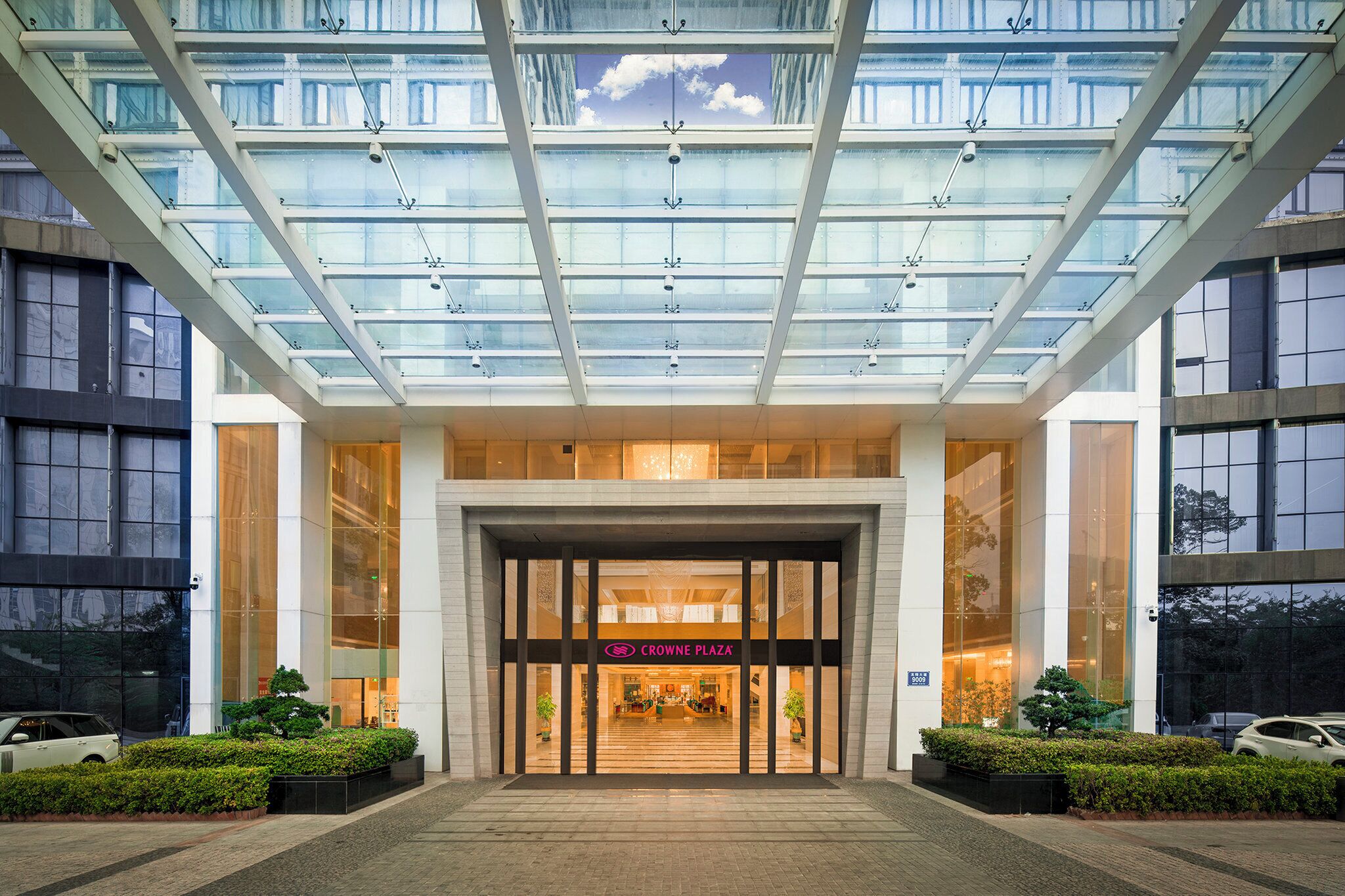 A modern building with a glass entrance and a sign for Crowne Plaza.