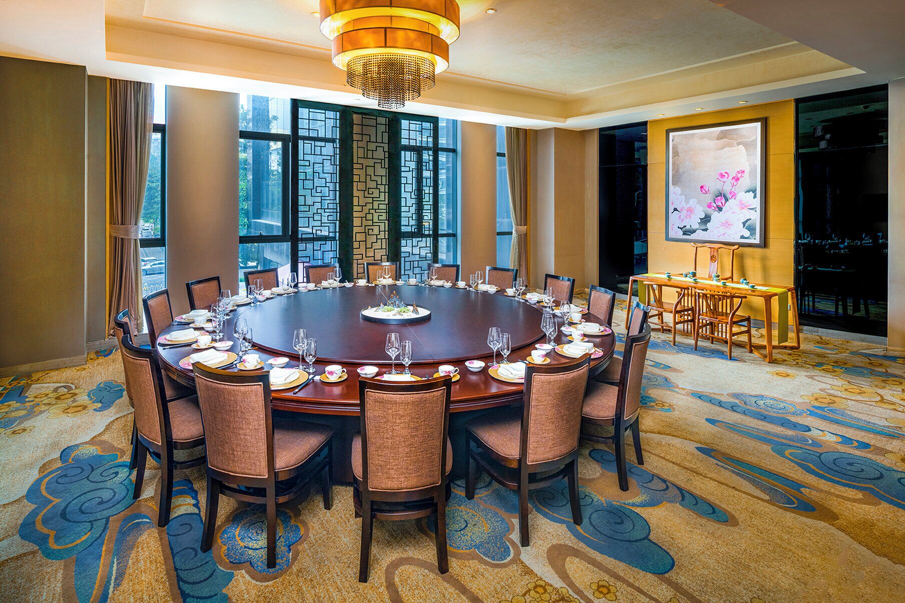 Een vergaderzaal met een ronde tafel, stoelen en een kroonluchter.