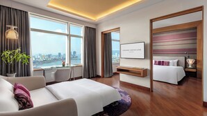 A modern hotel room with a large bed, a desk, and a view of the city. - Grand Mercure Danang (Da Nang)