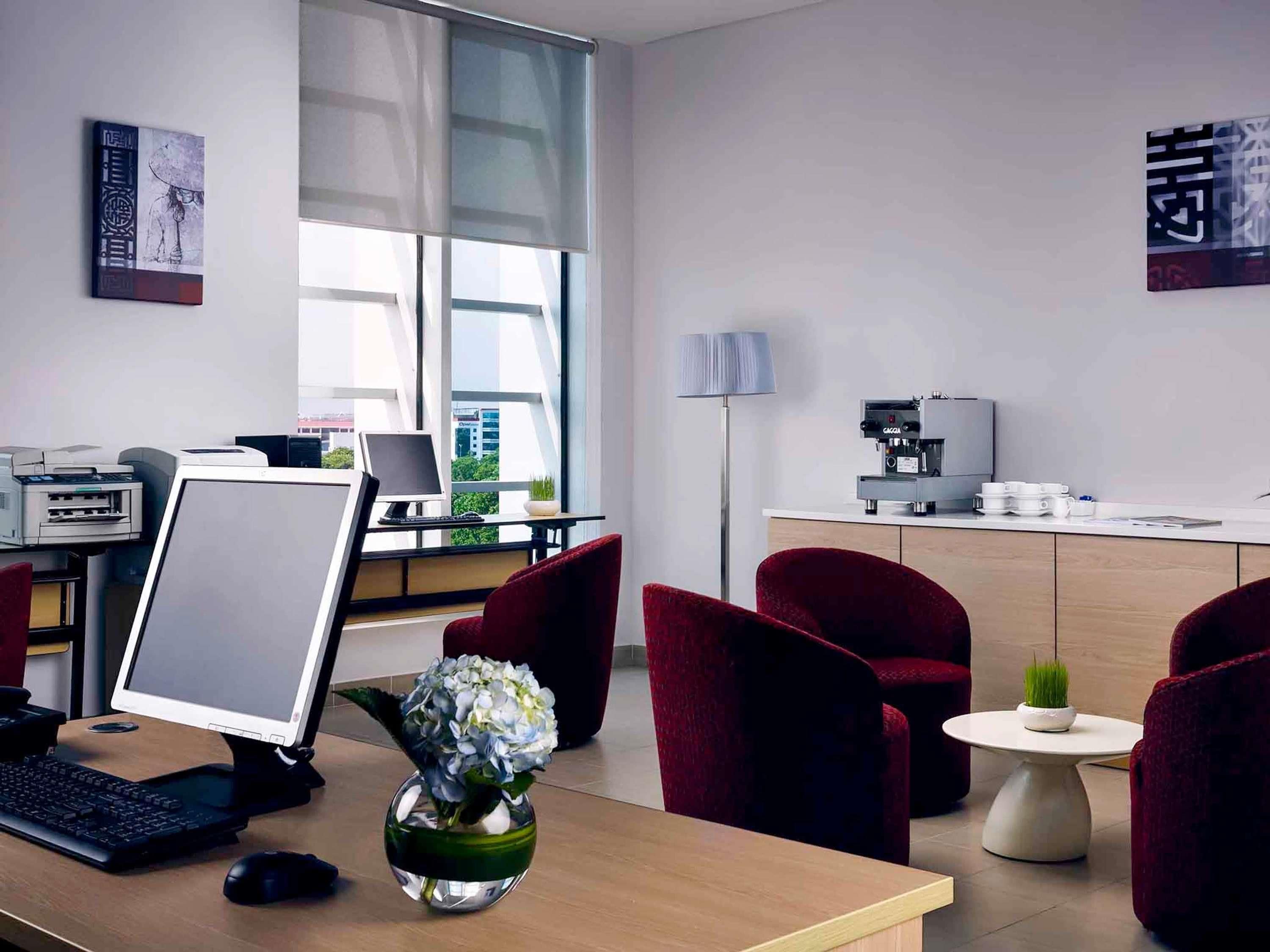 A modern office with a desk, computer, printer, and coffee machine.