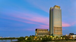 A high-rise hotel with a modern design, featuring a prominent 'Grand Mercury' sign at the top. - Grand Mercure Danang (Da Nang)