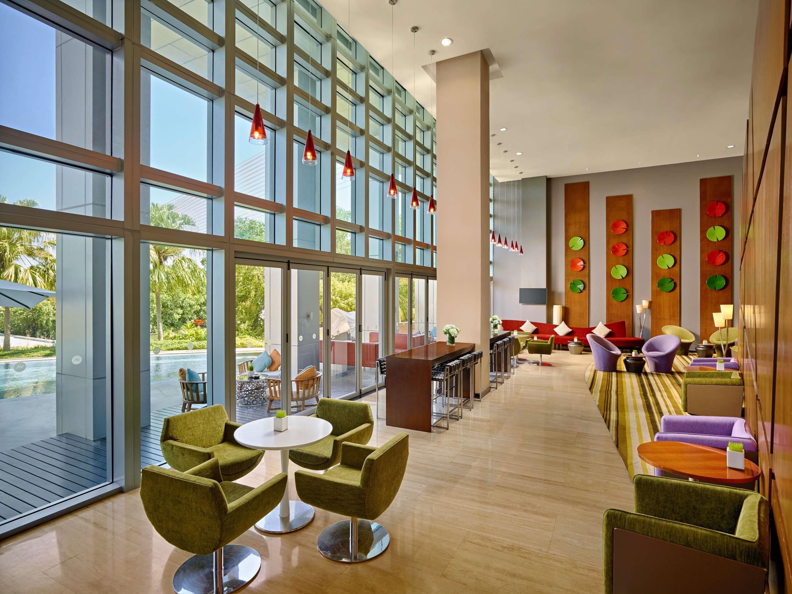 A spacious lobby with large windows, a bar area, and modern seating arrangements.