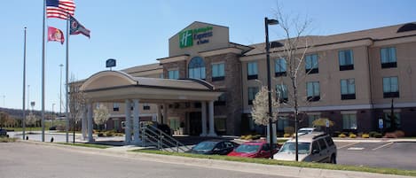A Holiday Inn Express hotel with a covered entrance, parking lot, and flags.