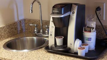 Una cafetera Keurig con una bandeja de goteo, un lavabo y una bolsa de té premium Bigelow.