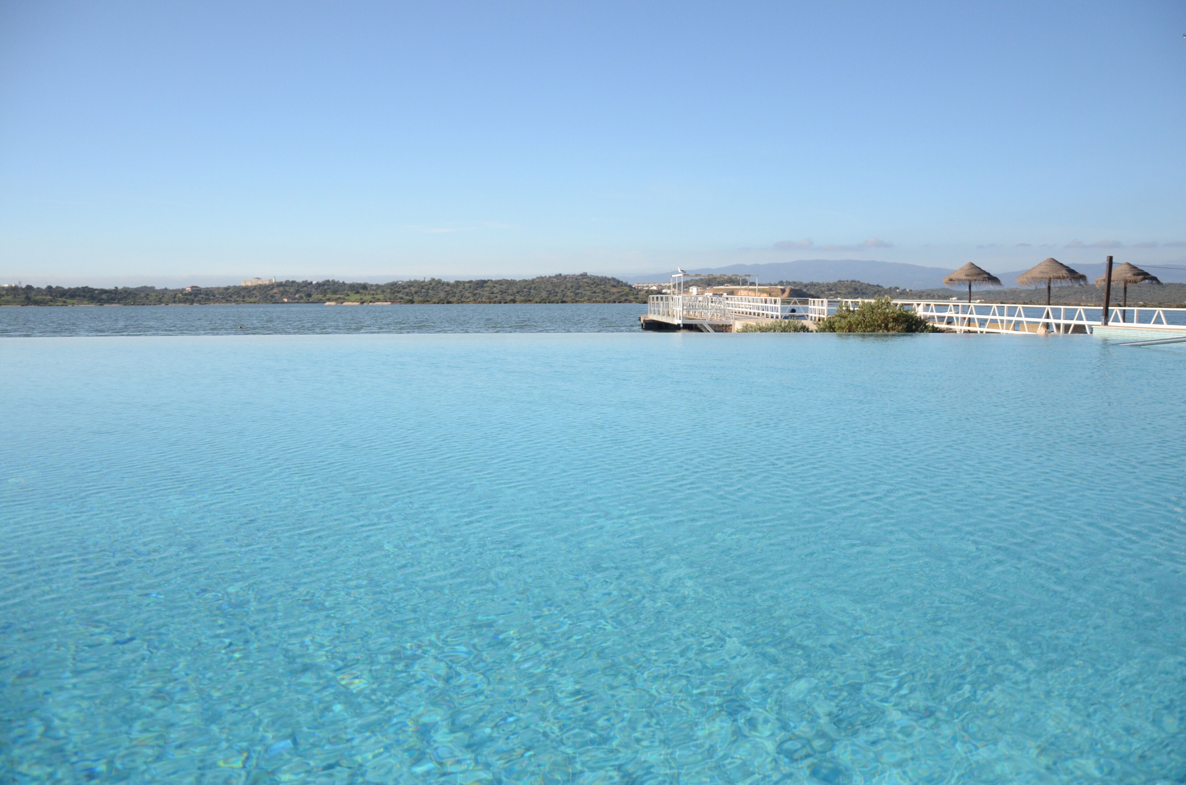 Een binnenzwembad, een buitenzwembad en parasols bij het zwembad