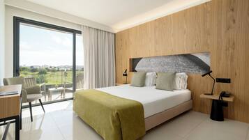Une chambre d’hôtel moderne, dotée d’un grand lit, d’un bureau, d’une chaise et offrant une vue sur l’extérieur.