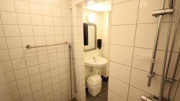 Een badkamer met een douche, wastafel en toilet.