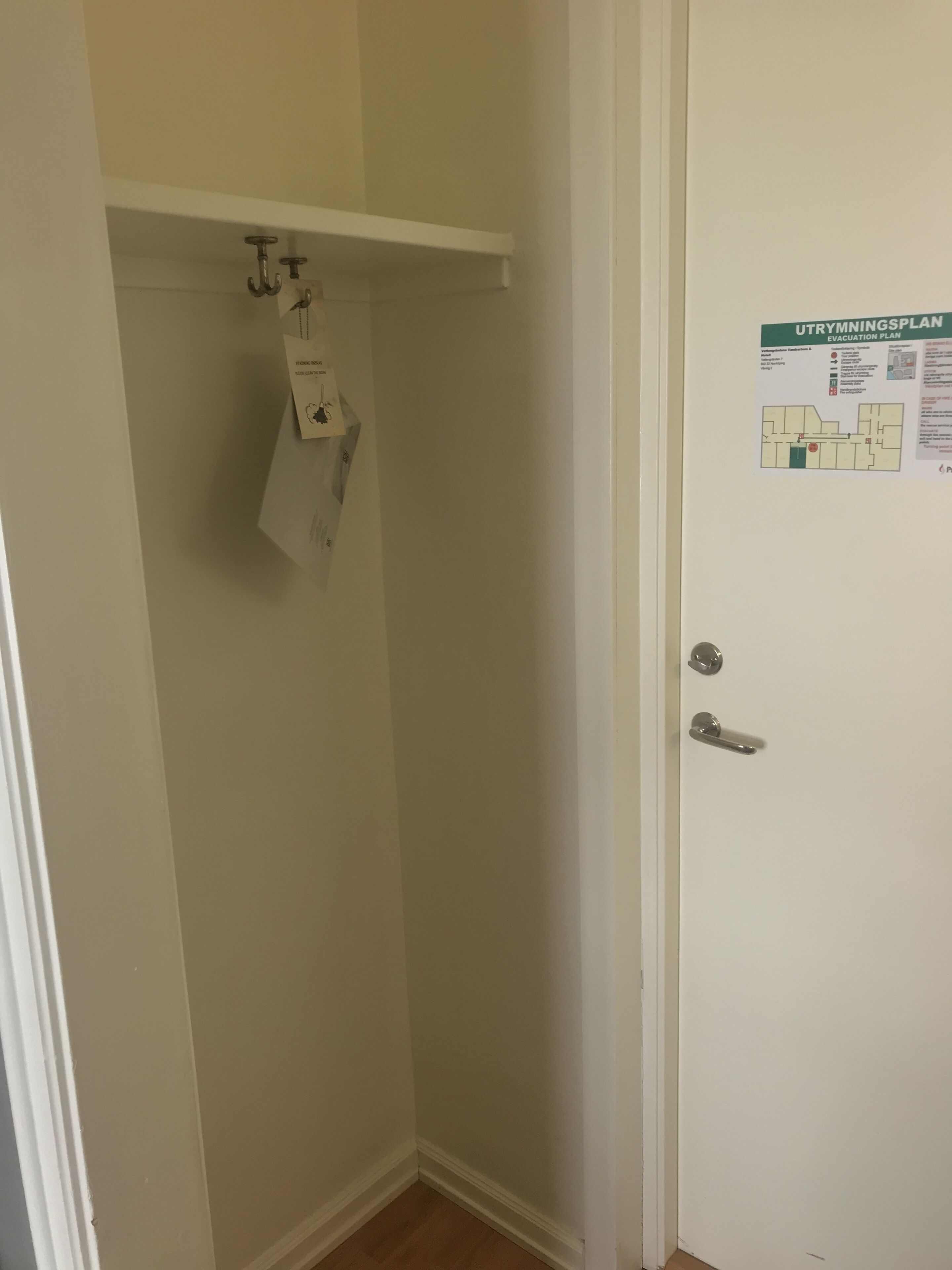 A small, narrow bathroom with a white door and a white towel hanging on a towel rack.