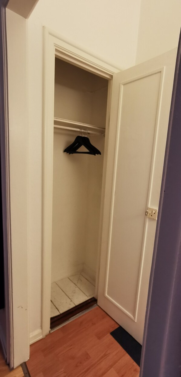 Un armario con barra para colgar y una puerta.