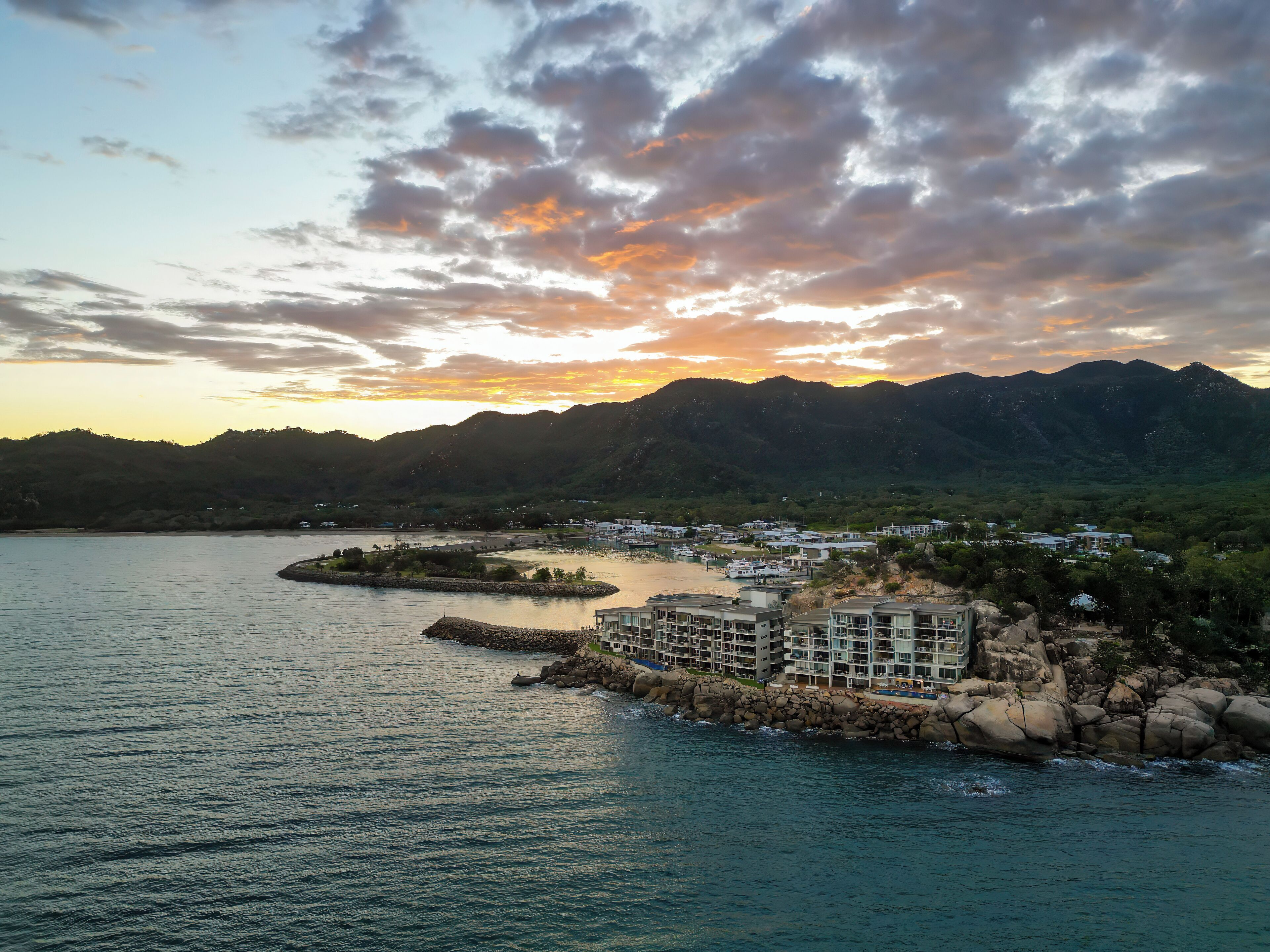 Un hôtel situé sur la côte, offrant une vue sur la mer et les montagnes.