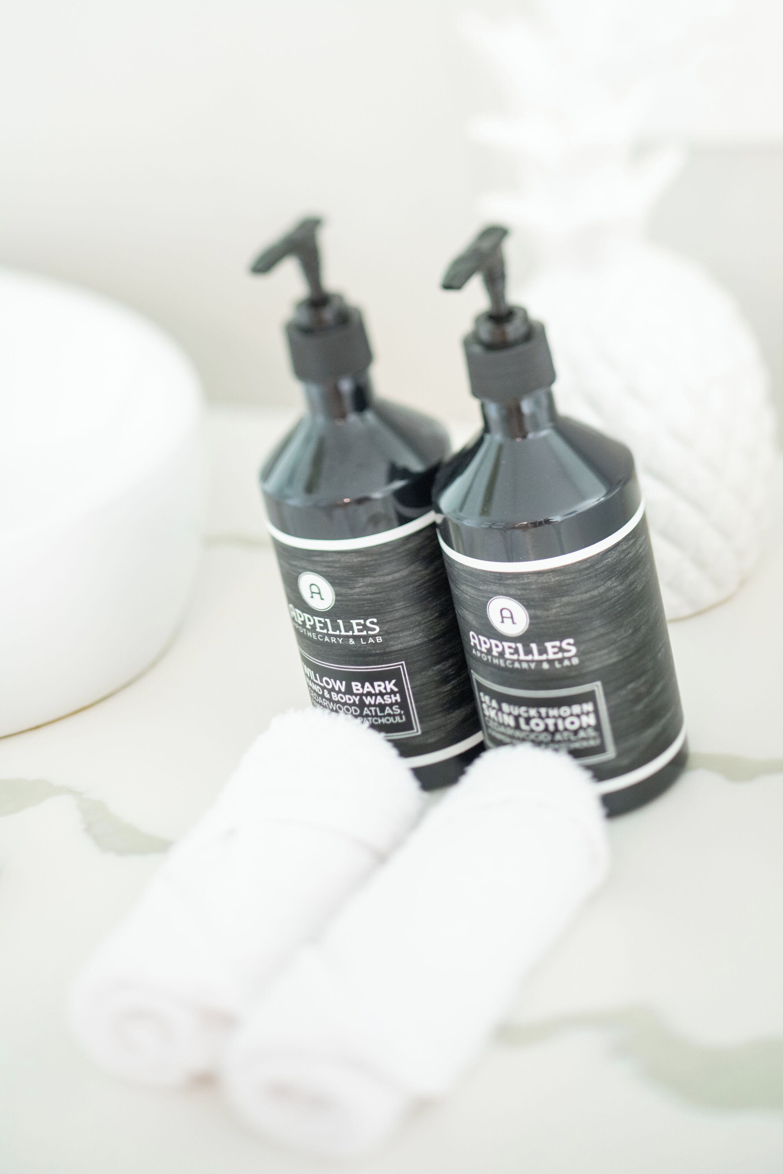 Two bottles of skincare products labeled 'Appelles' on a white surface.