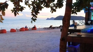 Um espaço de relaxamento à beira-mar, com assentos e vista para o mar.