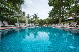 Una piscina al aire libre, sombrillas, sillones reclinables de piscina