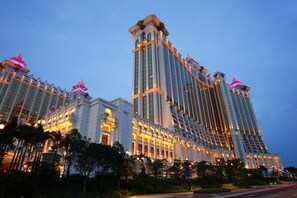 A multi-story hotel with a classic architectural design, featuring large windows and decorative elements on the facade. - Hotel Okura Macau (Cotai)