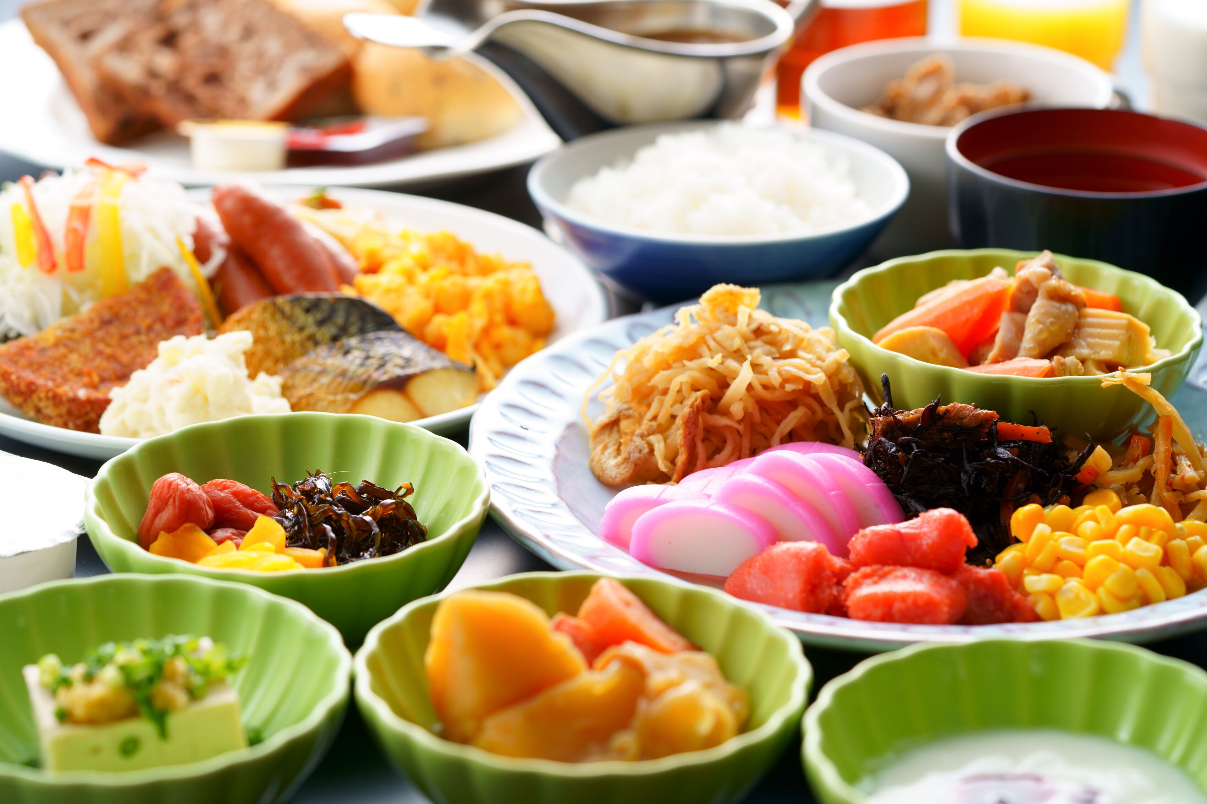 On peut voir une variété de plats servis dans des bols verts, notamment du riz, des légumes et de la viande, ce qui laisse supposer un choix de repas varié.