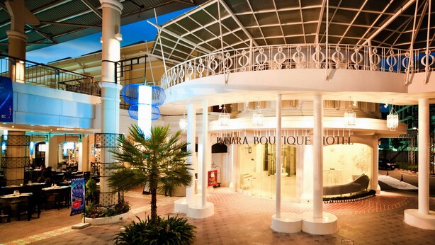 Un atrio interno con un'area centrale aperta, un hotel chiamato "MINARA BOUDOUE HOTEL" in basso, e una galleria coperta con ringhiere.