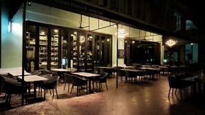 Un'area pranzo all'aperto con tavoli e sedie, un wine bar e un cartello che riporta la scritta "Dwine Italian bistro & wine bar".