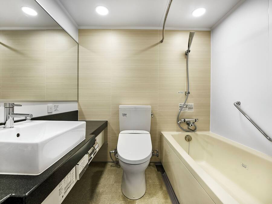 A modern bathroom with a sink, toilet, and bathtub.