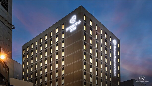 A Daiwa Roynet Hotel with a modern design, featuring a grid of windows and a prominent hotel logo on the facade.