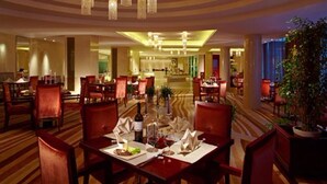 A hotel dining area with multiple tables, chairs, and chandeliers. - New Century Fengming Resort Zaozhuang (Zaozhuang)