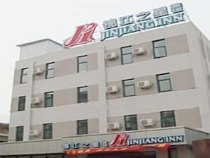 Monikerroksinen rakennus, jossa on kyltti, jossa lukee ”JINJIANGINN”, mikä osoittaa, että kyseessä on hotelli.