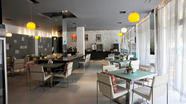 Cozinha moderna com ilha central, banquetas e iluminação pendente.