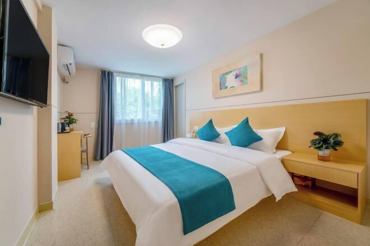 Relax in a spacious room with a large bed, flat-screen TV, and a comfortable nightstand.