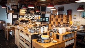 Un espace buffet avec différents stands de nourriture, des meubles en bois et des lampes suspendues.