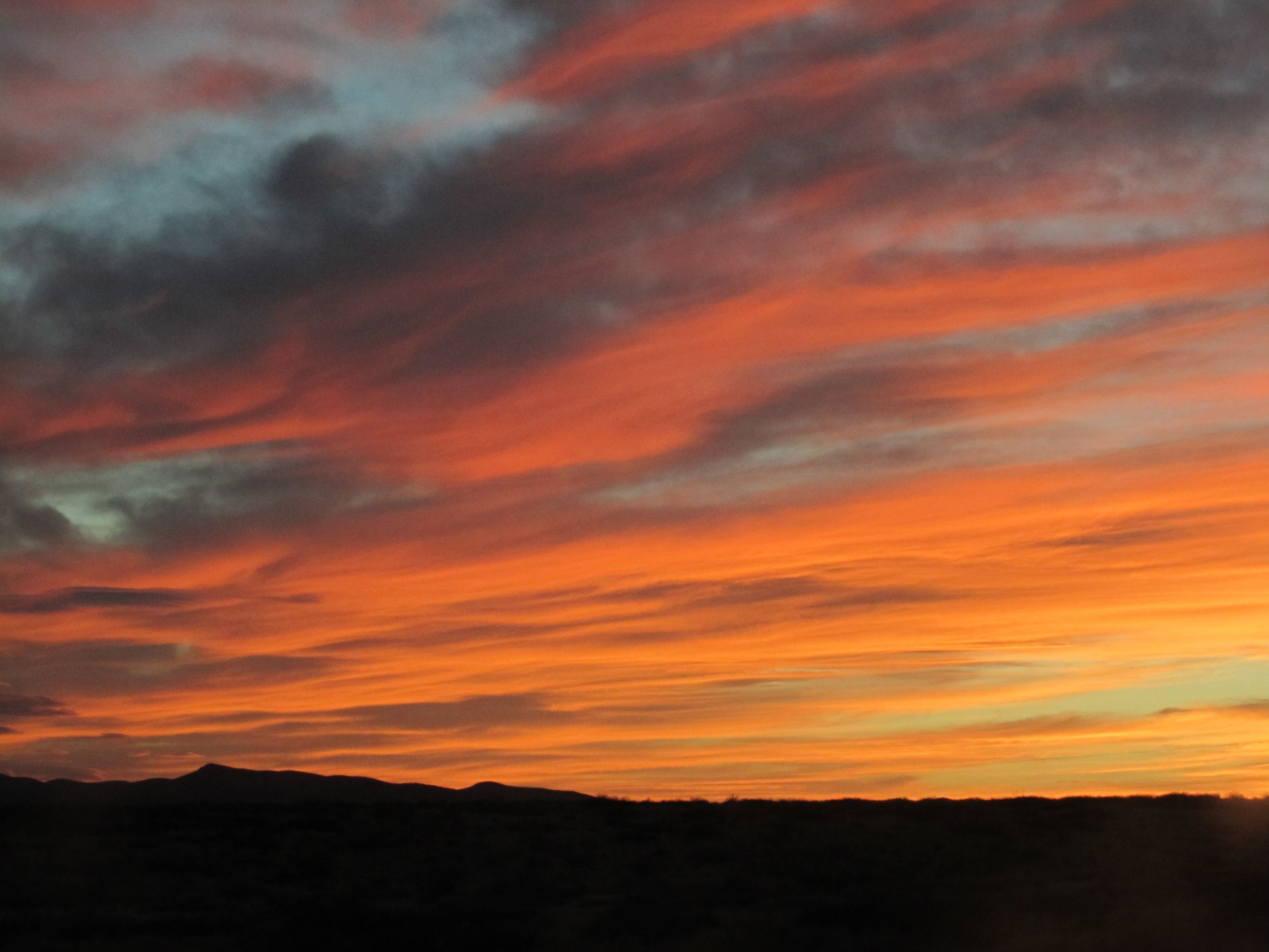 Un atardecer sobre un paisaje montañoso.
