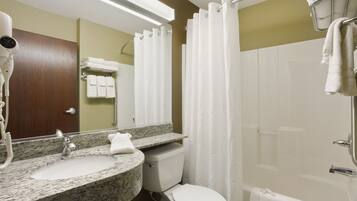 Un baño con lavamanos de granito, inodoro blanco y cabina de ducha de vidrio.
