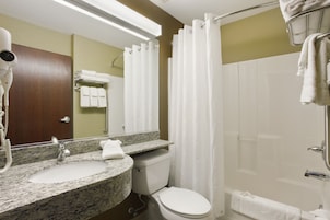Un baño con lavamanos de granito, inodoro blanco y cabina de ducha de vidrio.