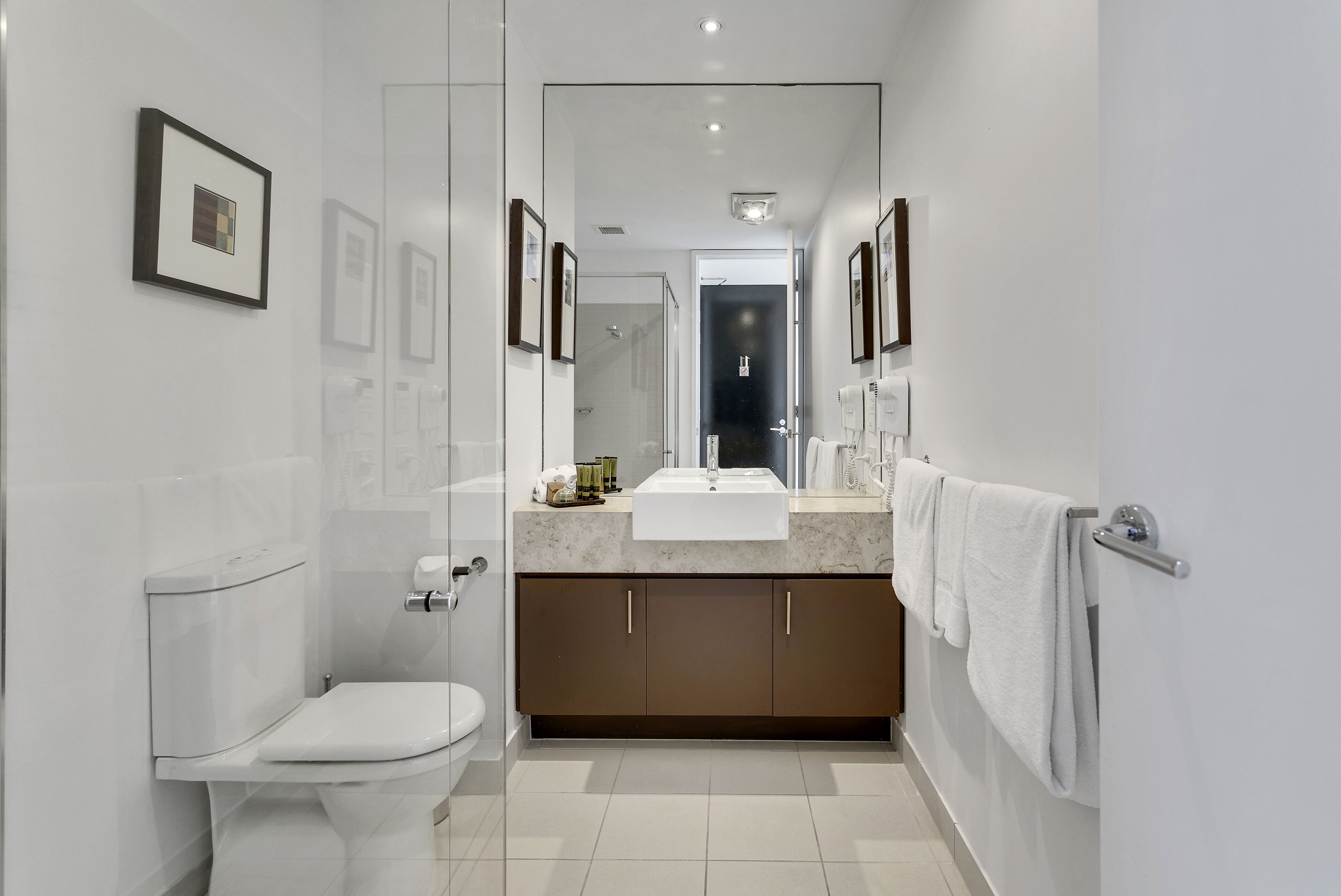 Un baño moderno con inodoro, lavabo y tocador.