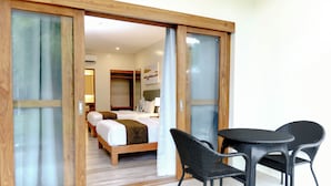 A hotel room with a bed, a desk, and two chairs. - Almont Inland Resort (Butuan)