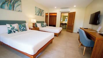 A hotel room with two single beds, a desk with a chair, a television, and artwork on the walls.