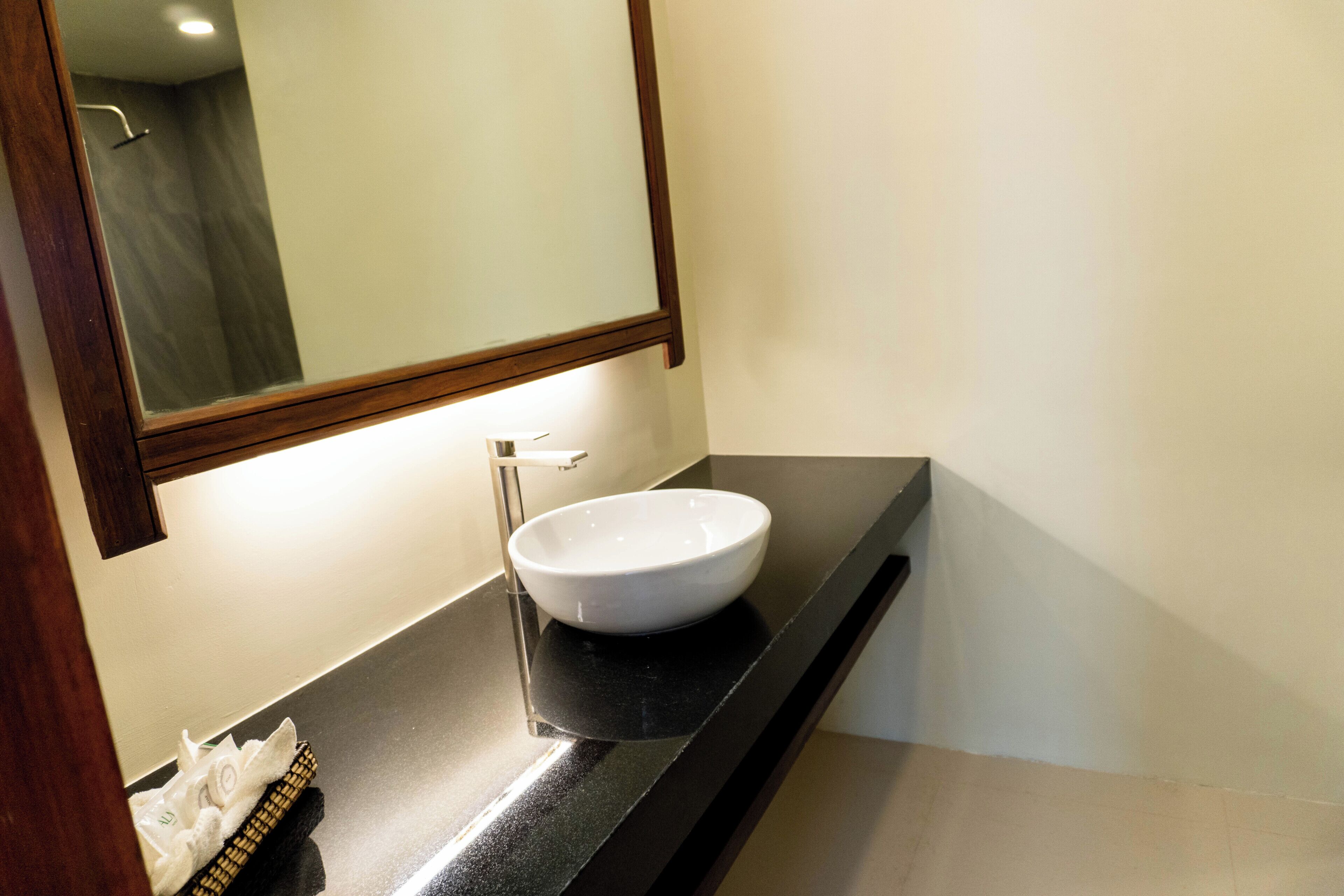 A bathroom with a white sink, a mirror, and a towel rack.